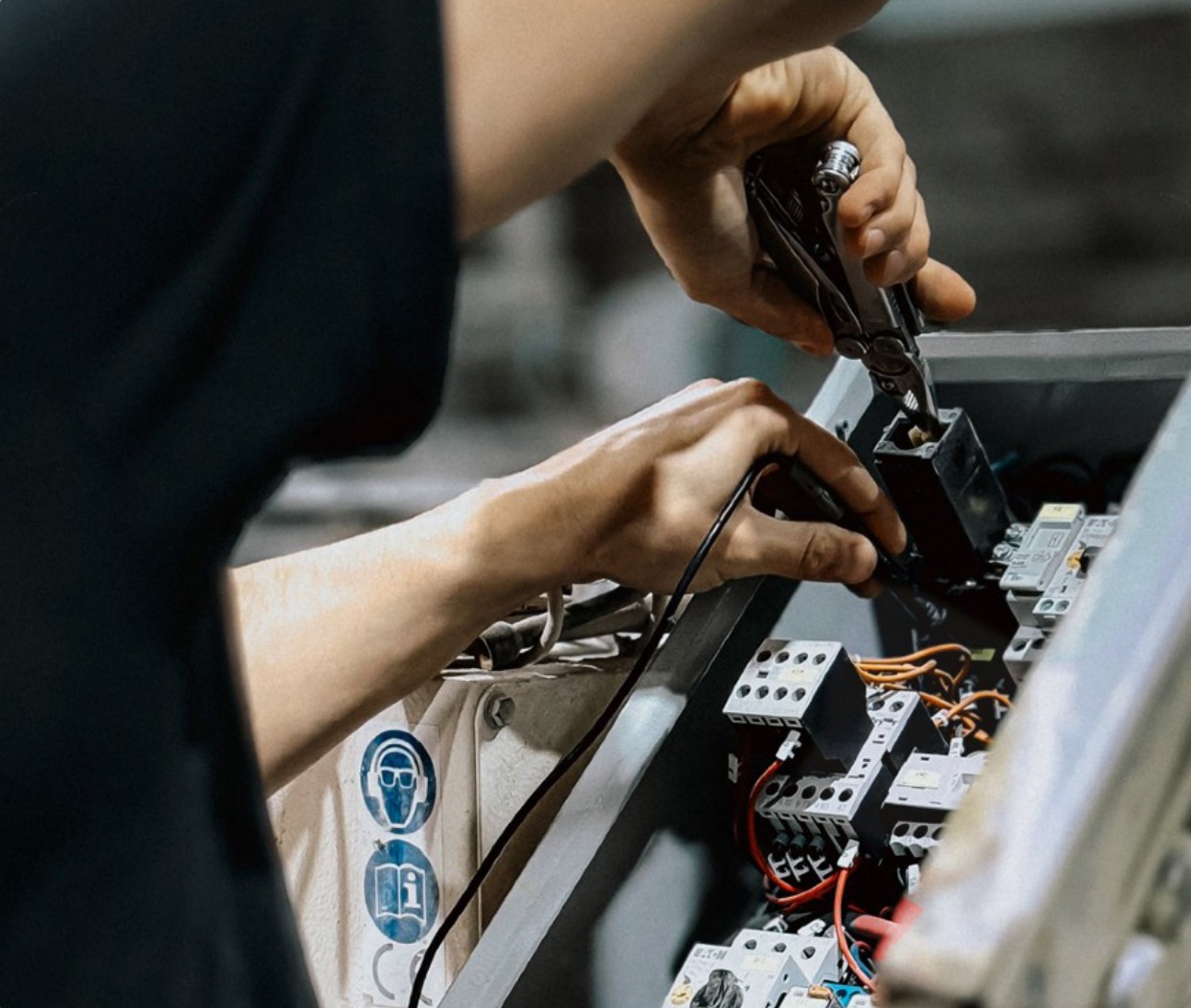 Electrician terminating wiring inside a marine electrical panel